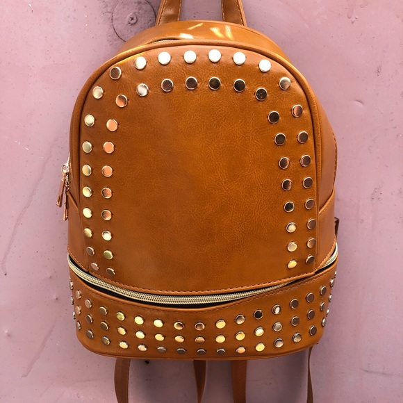 Handbags - Selling a tan purse with studs surround the purse.